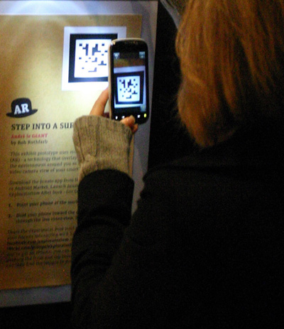 Fig 1: Exploratorium After Dark visitor scanning a 2-D LLA (Longitude-Latitude-Altitude) marker to access a 3-D augmented-reality exhibit on her smartphone